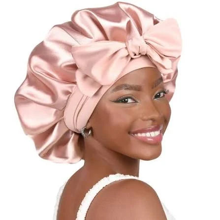Woman wearing a satin hair bonnet with bow detail